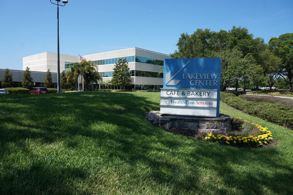Lakeview Center in Tampa, with palms, reflective windows and a HealthPlan Services sign