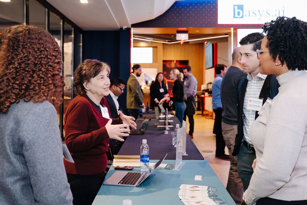 Participants talking across a display table at a Healthworx accelerator gathering