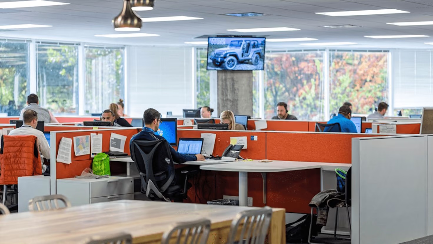 Hearst Connecticut newsroom with staff at desks separated by orange dividers