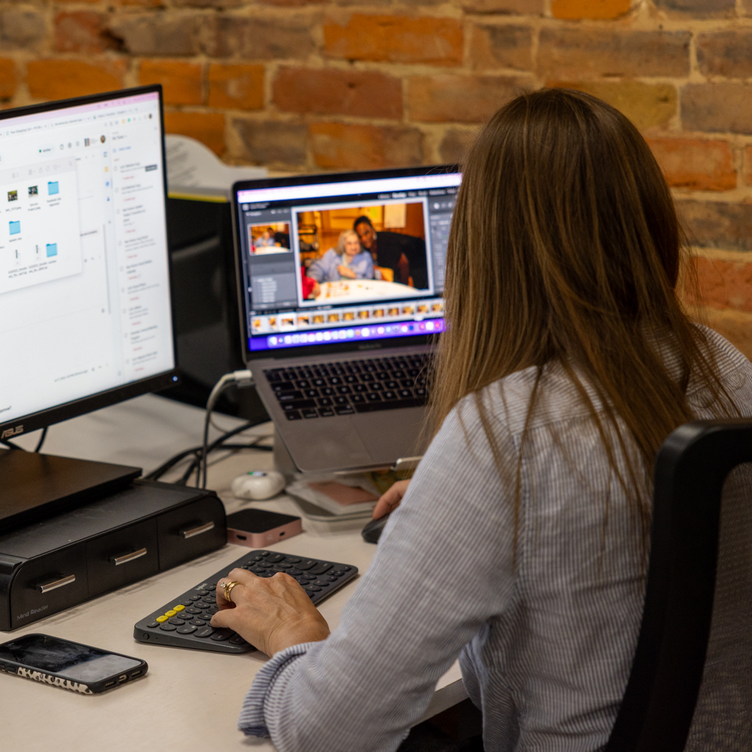 A Heartland staff member editing visual content at a desk