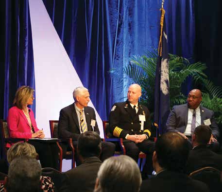 Heather Hoopes-Matthews, at left, moderates a panel with three public safety leaders on a stage.