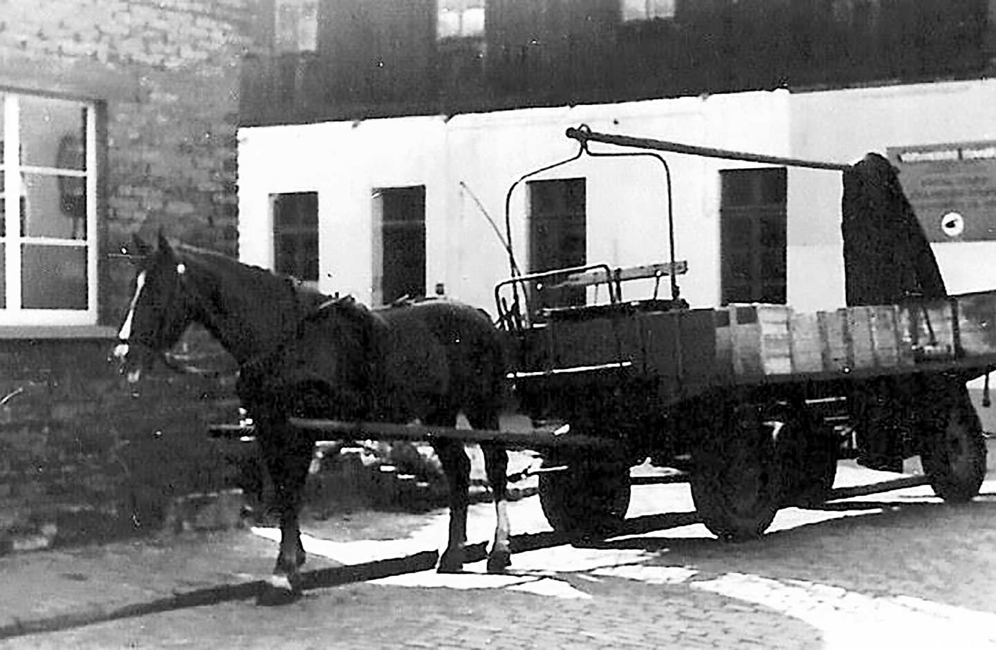 Historical photograph of Lisa beside a Hellmann horse-drawn cart