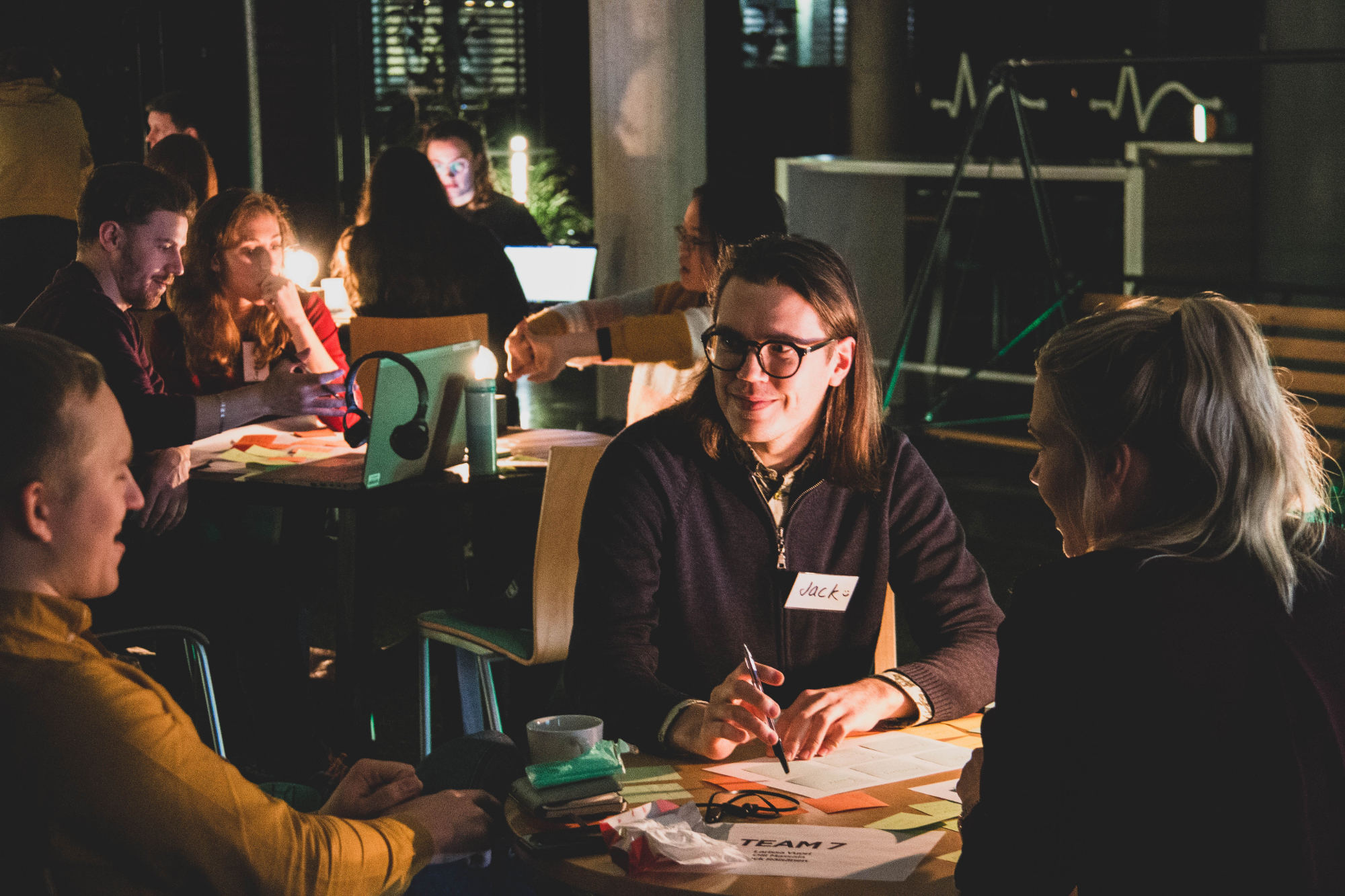 Three participants collaborating around a laptop at a Think Company workshop