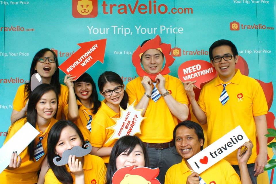 Travelio's team in yellow shirts posing with playful travel signs at the 2015 exclusive launch