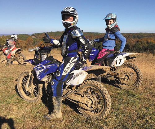 Henry DePhillips and his daughter Olivia with dirt bikes on a wooded Tennessee trail