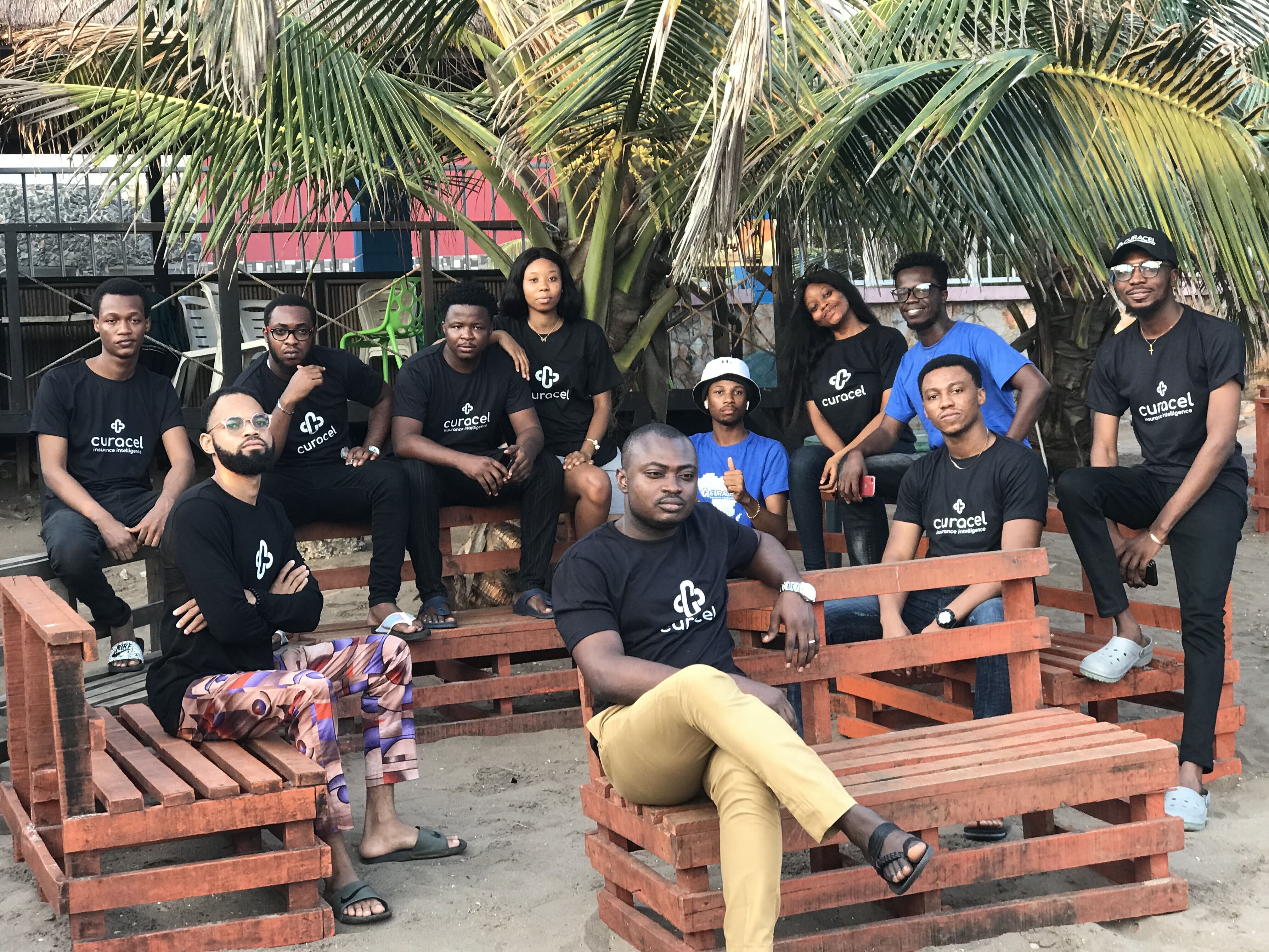 The Curacel team gathered outdoors in company shirts