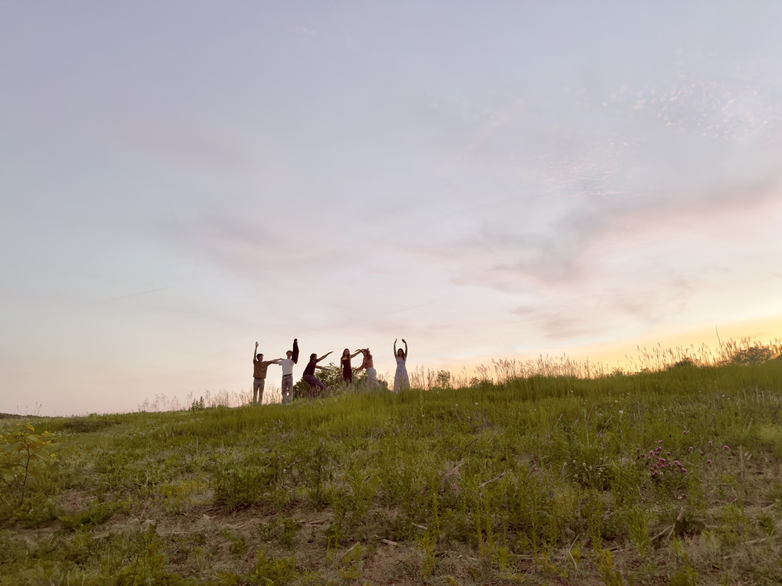 A group photographed outdoors at sunset on Hera’s company story page