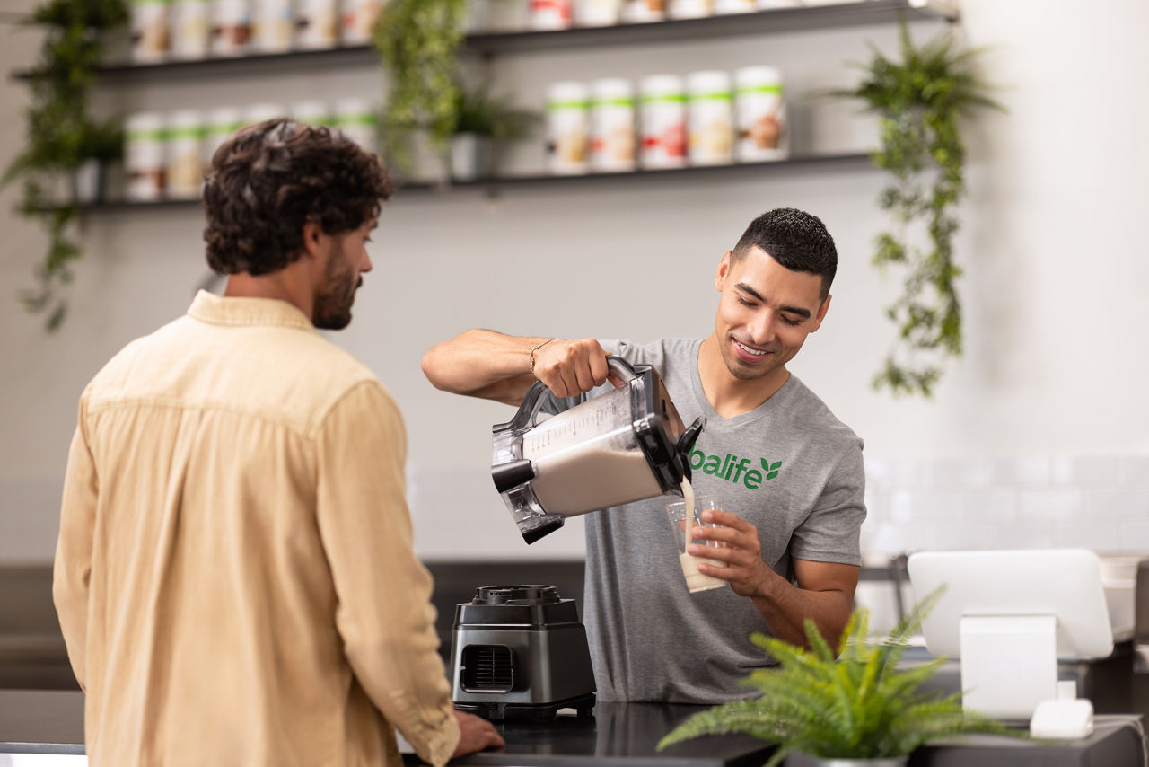 Herbalife marketing photograph of a man pouring a shake for another man