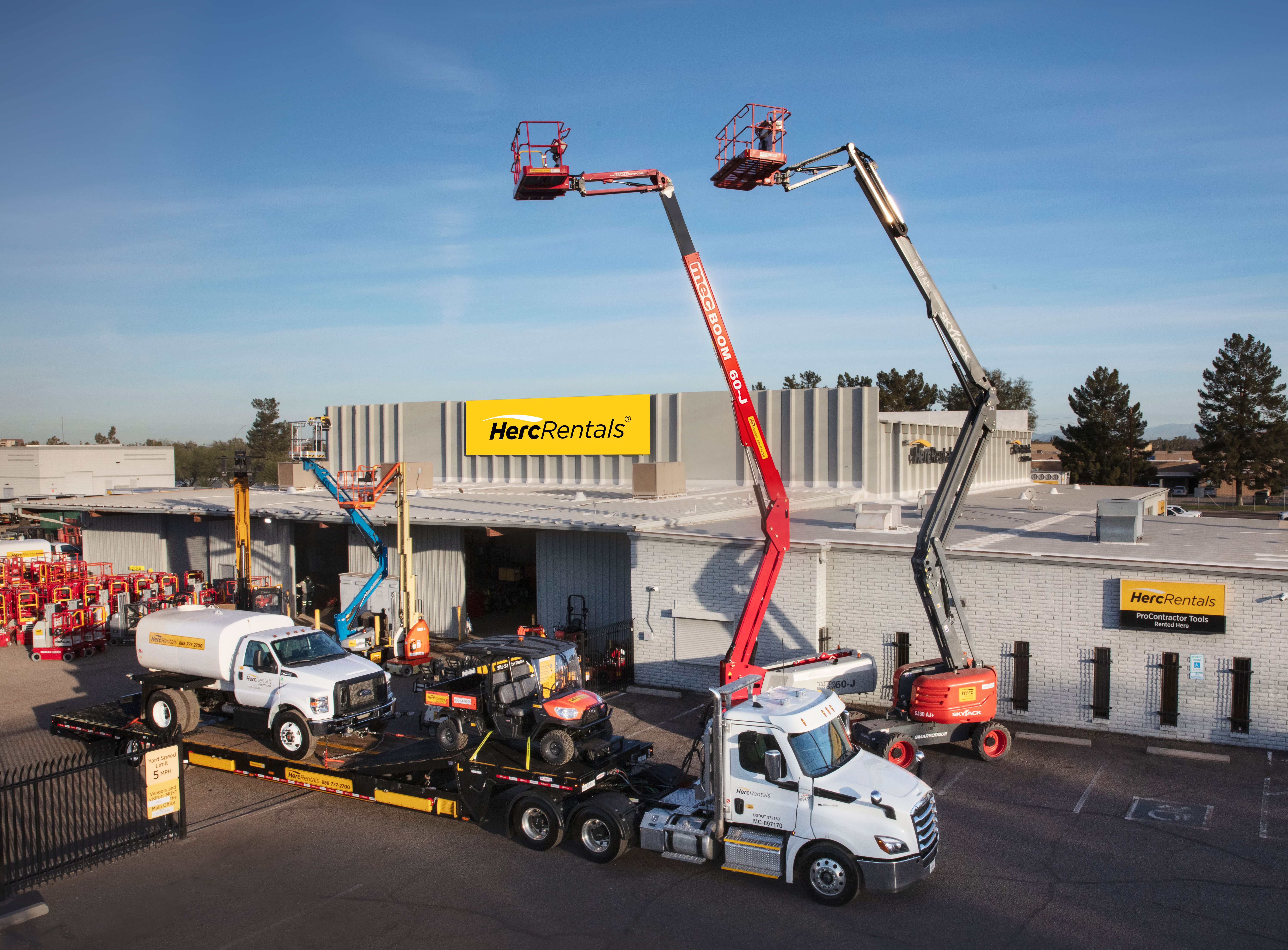 Herc rental branch with raised boom lifts, trucks and equipment