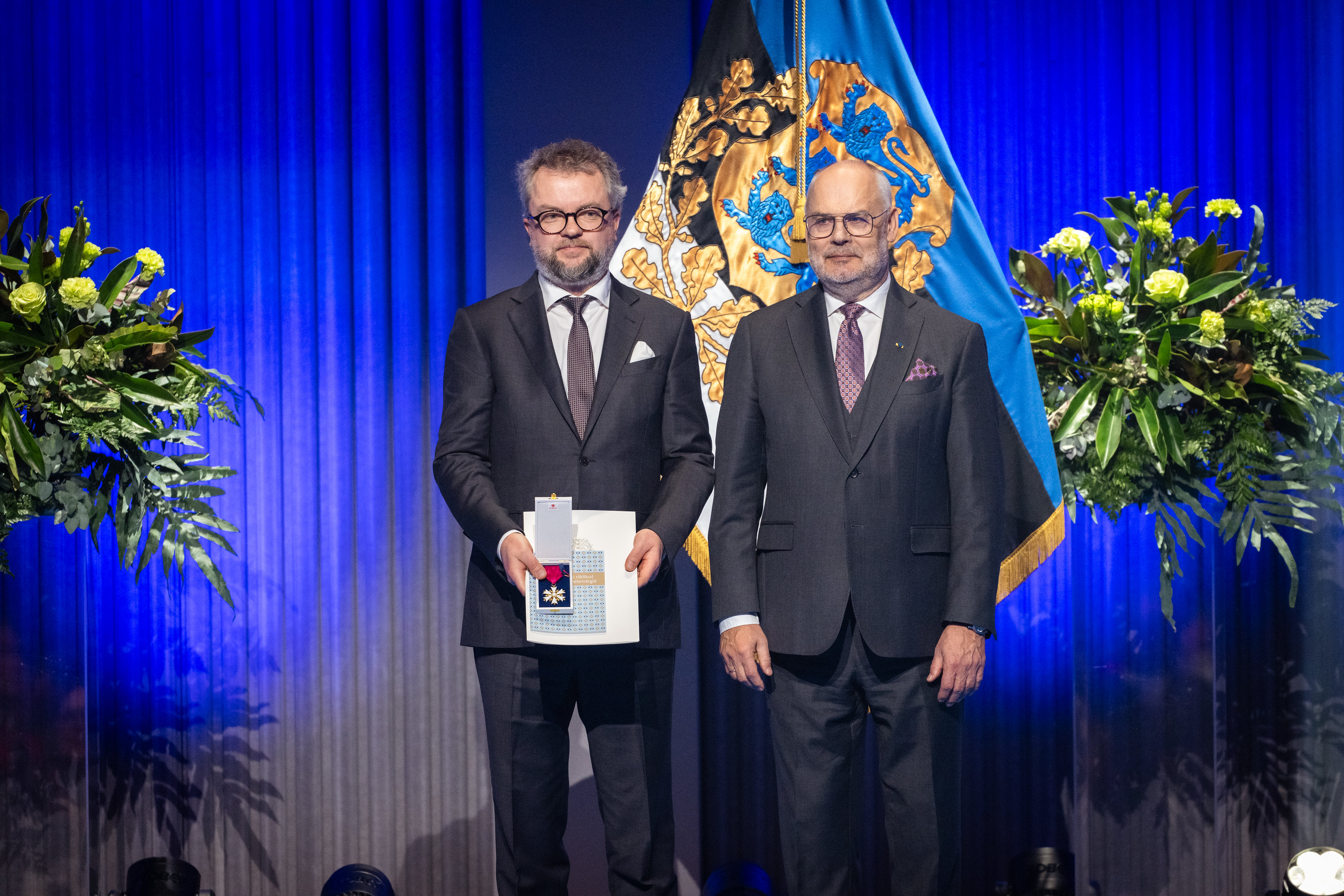 Herty Tammo holding his Order of the White Star alongside President Alar Karis