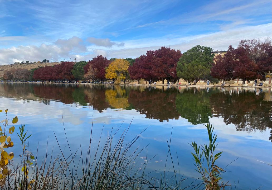 Autumn trees and people along the bank reflected in Hesperia Lake