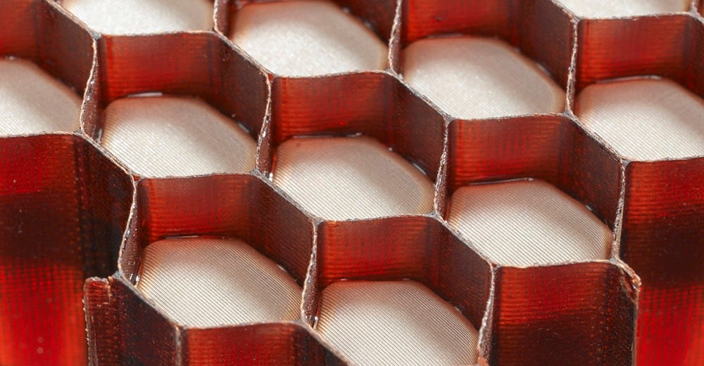 Red Acousti-Cap honeycomb material photographed by Hexcel