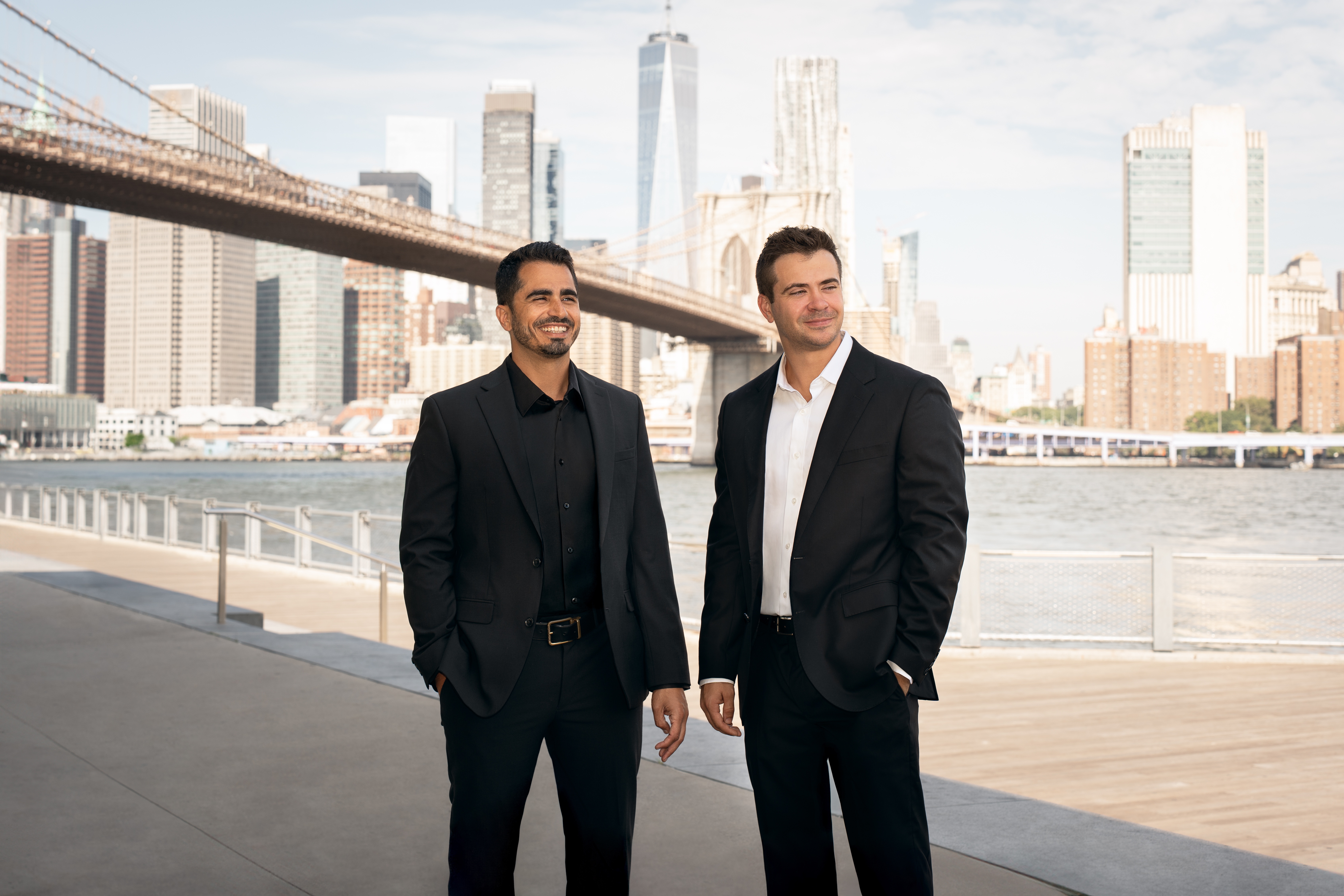 HIFI co-founders Mohamed Afifi, left, and Zach Walsh, right, beside the East River with the Brooklyn Bridge behind them