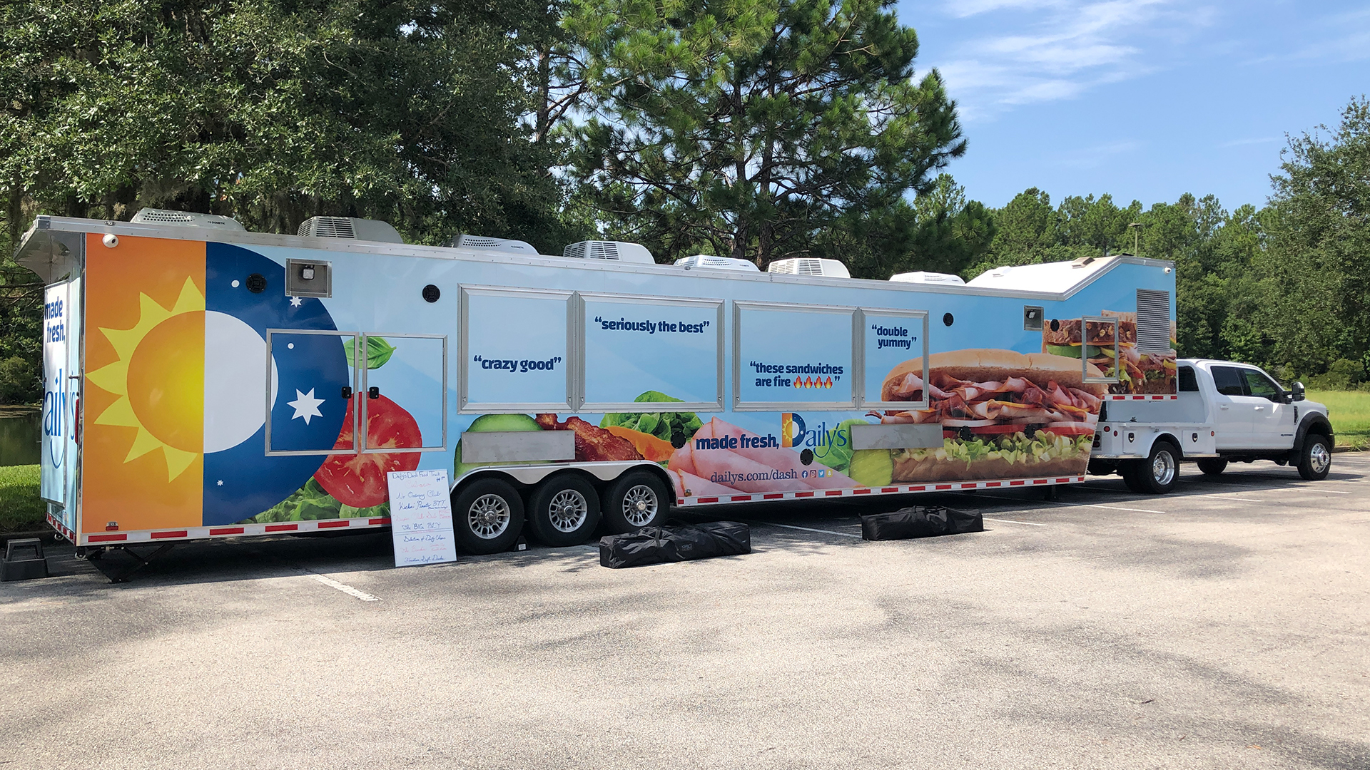 A Daily's food truck wrapped in blue graphics and oversized sandwich photography