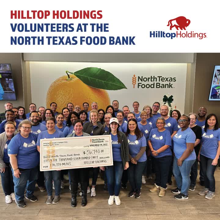 Hilltop employees in blue volunteer shirts holding a donation check at North Texas Food Bank
