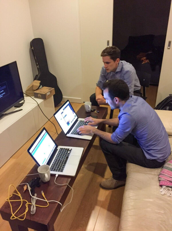 Jordan O’Reilly and Murray Bunton working with laptops in a living room