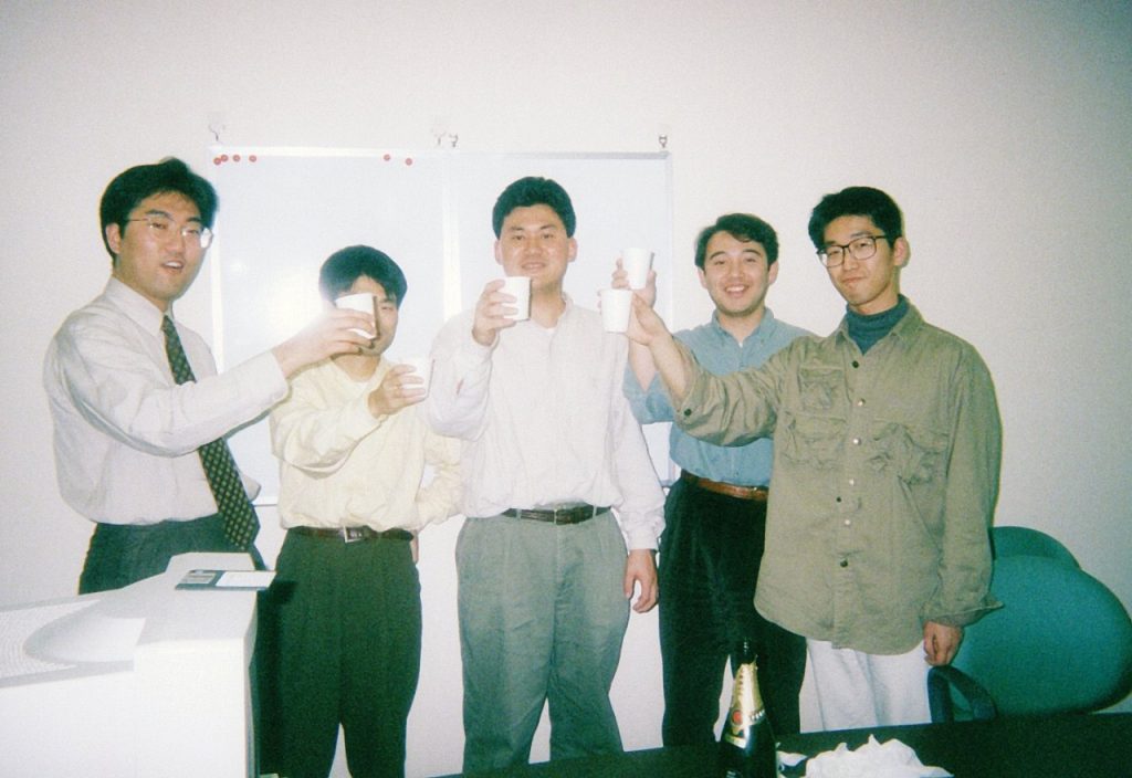Hiroshi Mikitani, at center, raising a paper cup with fellow Rakuten founding members