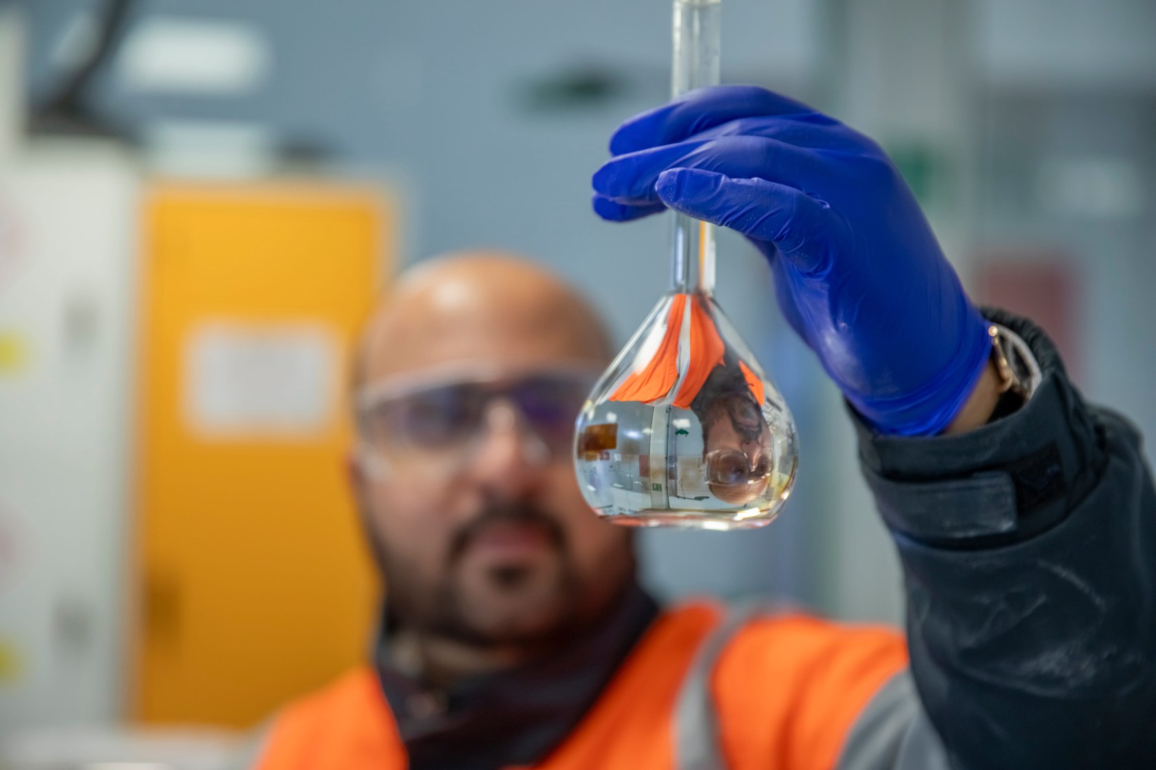 A Bouskoura laboratory technician holds a glass flask while inspecting its contents