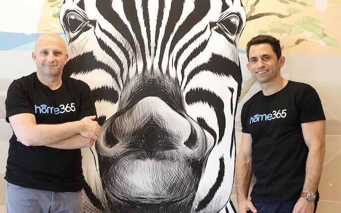 Home365 leaders Daniel Shaked and Dvir Milo standing in front of zebra artwork
