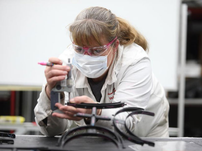 A Honda associate checks the fit of a newly produced face-shield frame