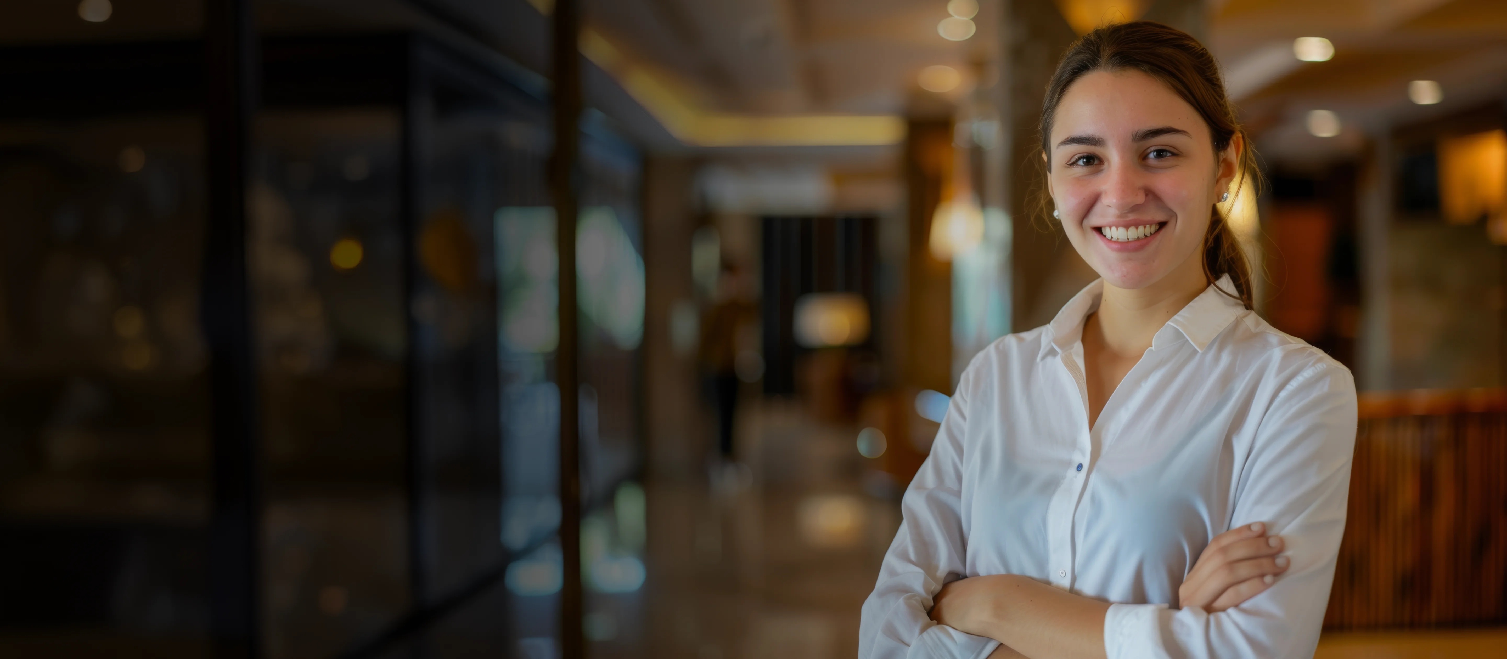 HotelKey GuestKey marketing image of a smiling hospitality worker in a hotel interior