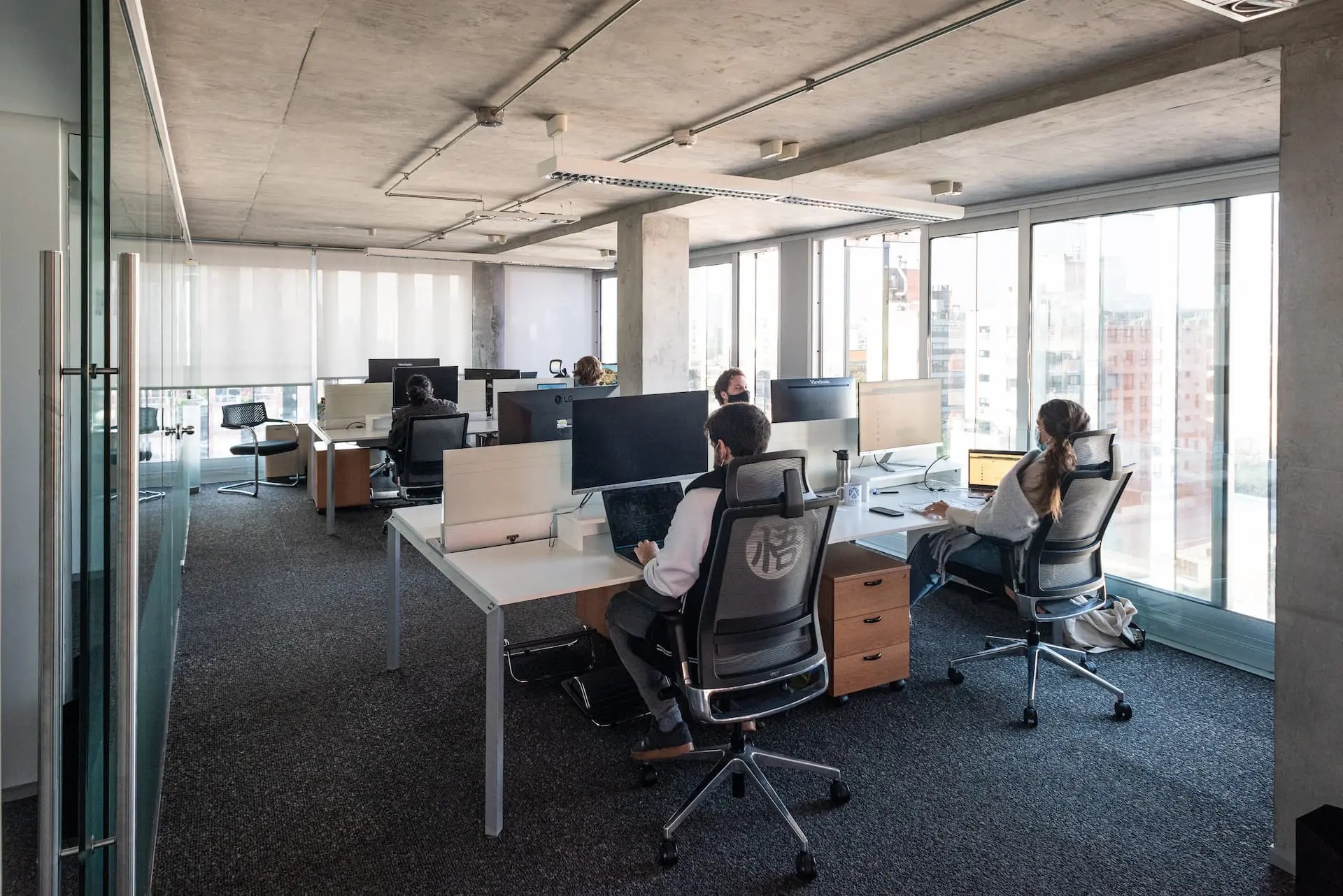 People working at desks in a bright Howdy office