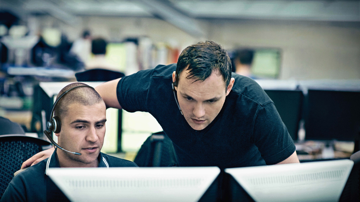 Two people working together at computer screens in an office