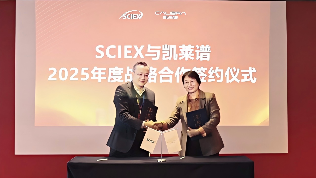 Hua-fen Liu, right, and Cai Junsong shaking hands while holding agreement folders at the 2025 SCIEX and Calibra signing ceremony