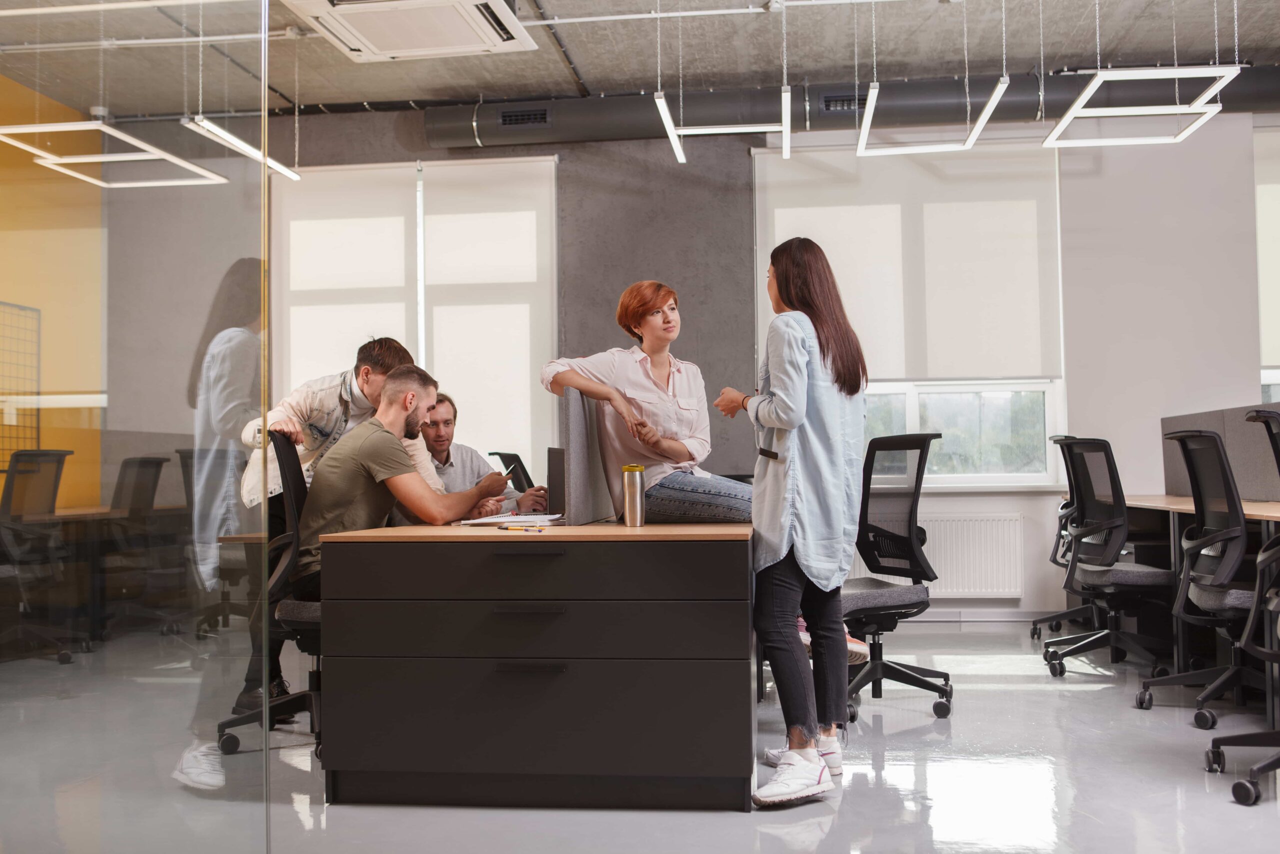 People gathered around a desk in a glass-walled workspace on HUB 4.0’s website