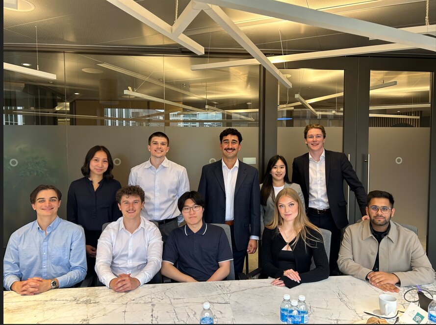 A group of HUB International interns and young professionals gathered around a conference table in a Canadian office