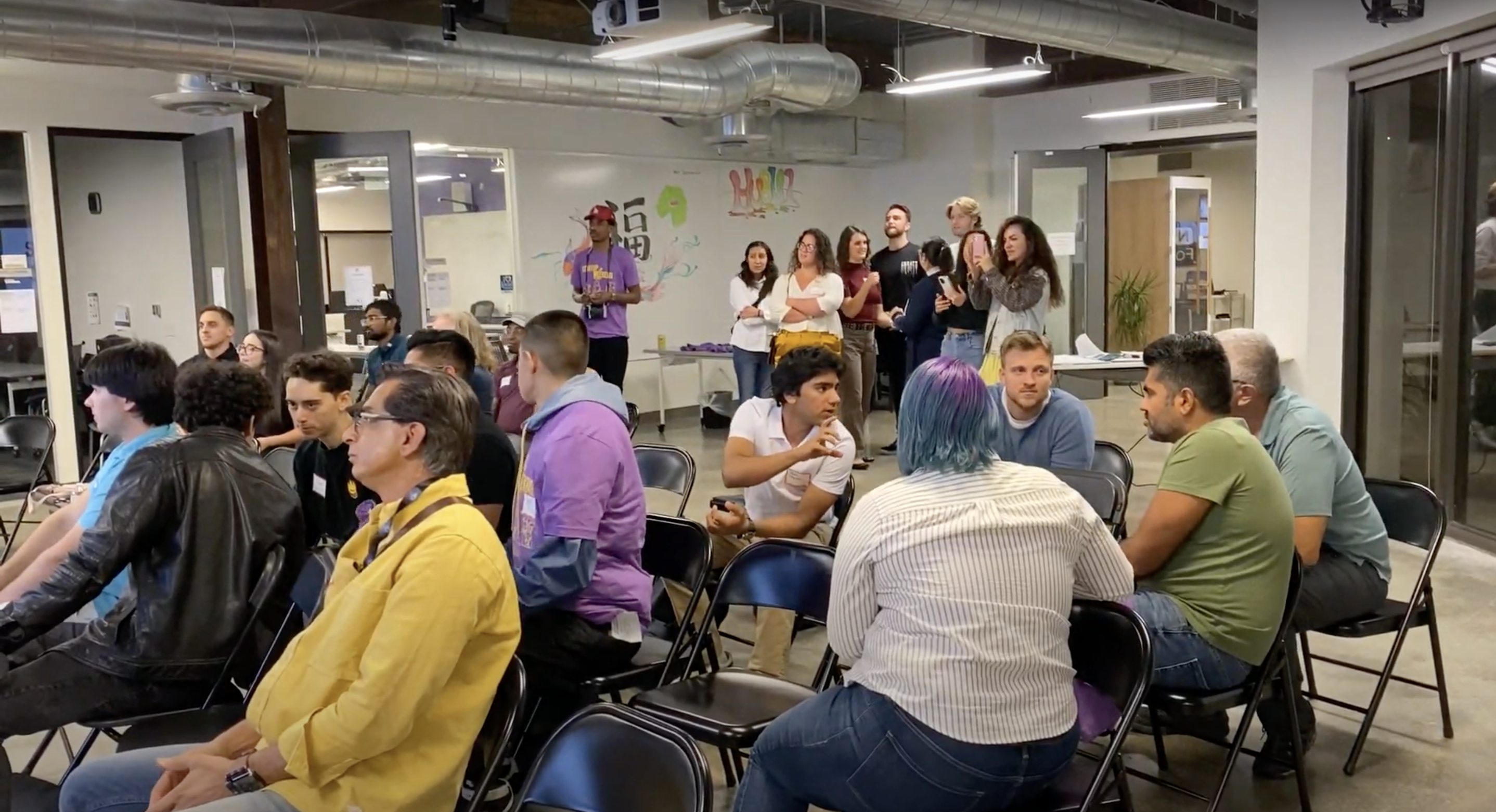 Participants chatting in groups at a Hub101 Startup Weekend event
