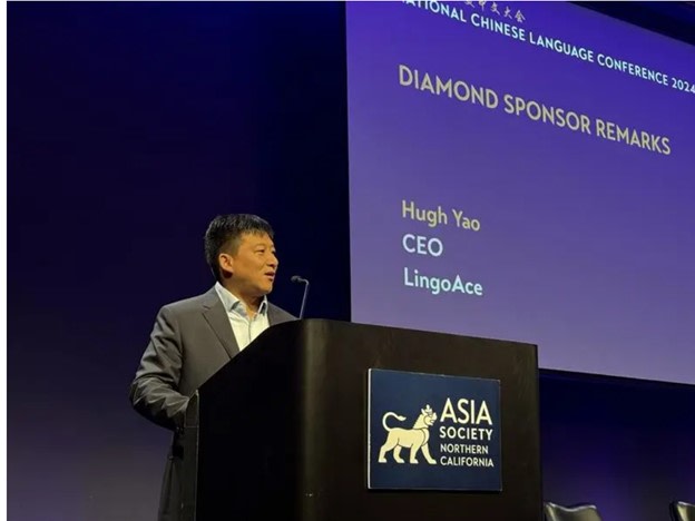 Hugh Yao speaking from a podium at a language education gathering