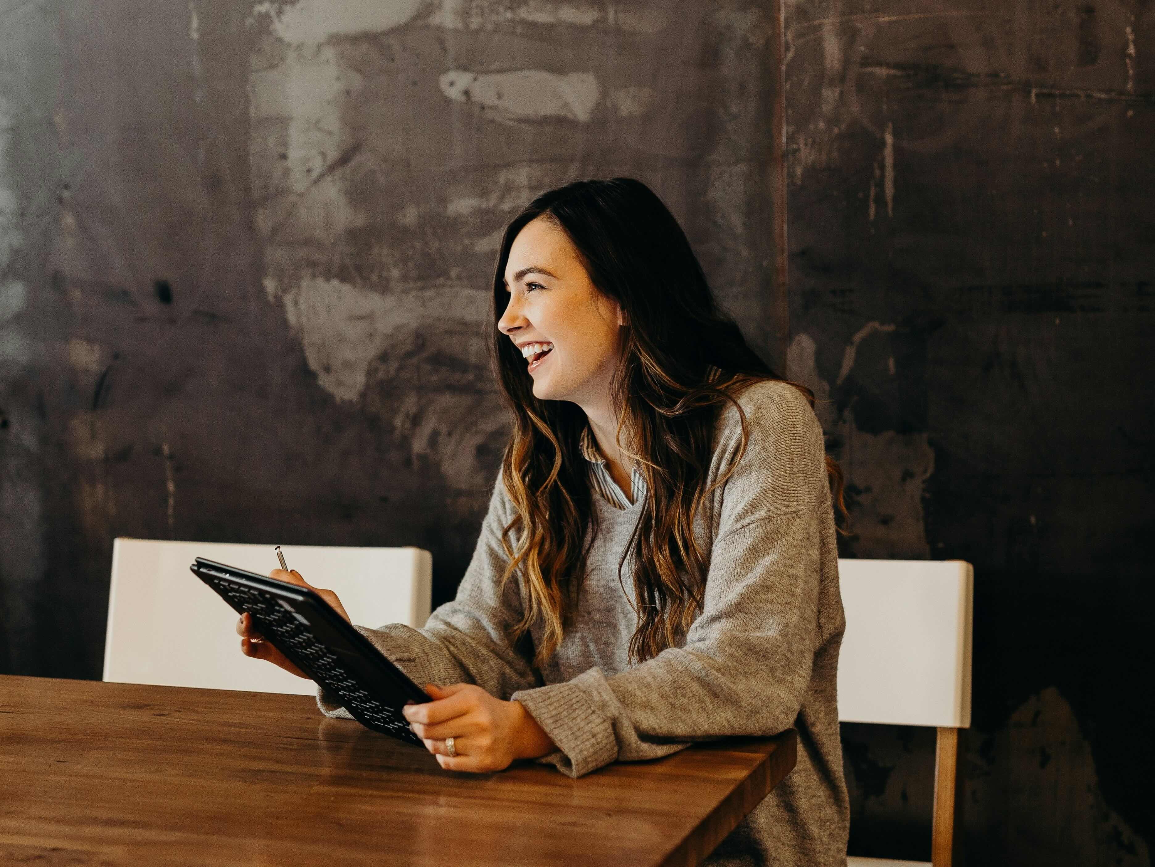 Recruiter smiling while holding a tablet during a conversation