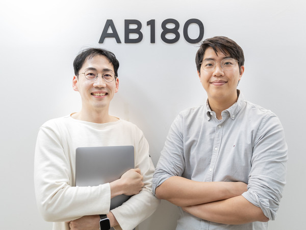 Hunjae Jung on the left holding a laptop, beside co-founder Roi Nam at AB180