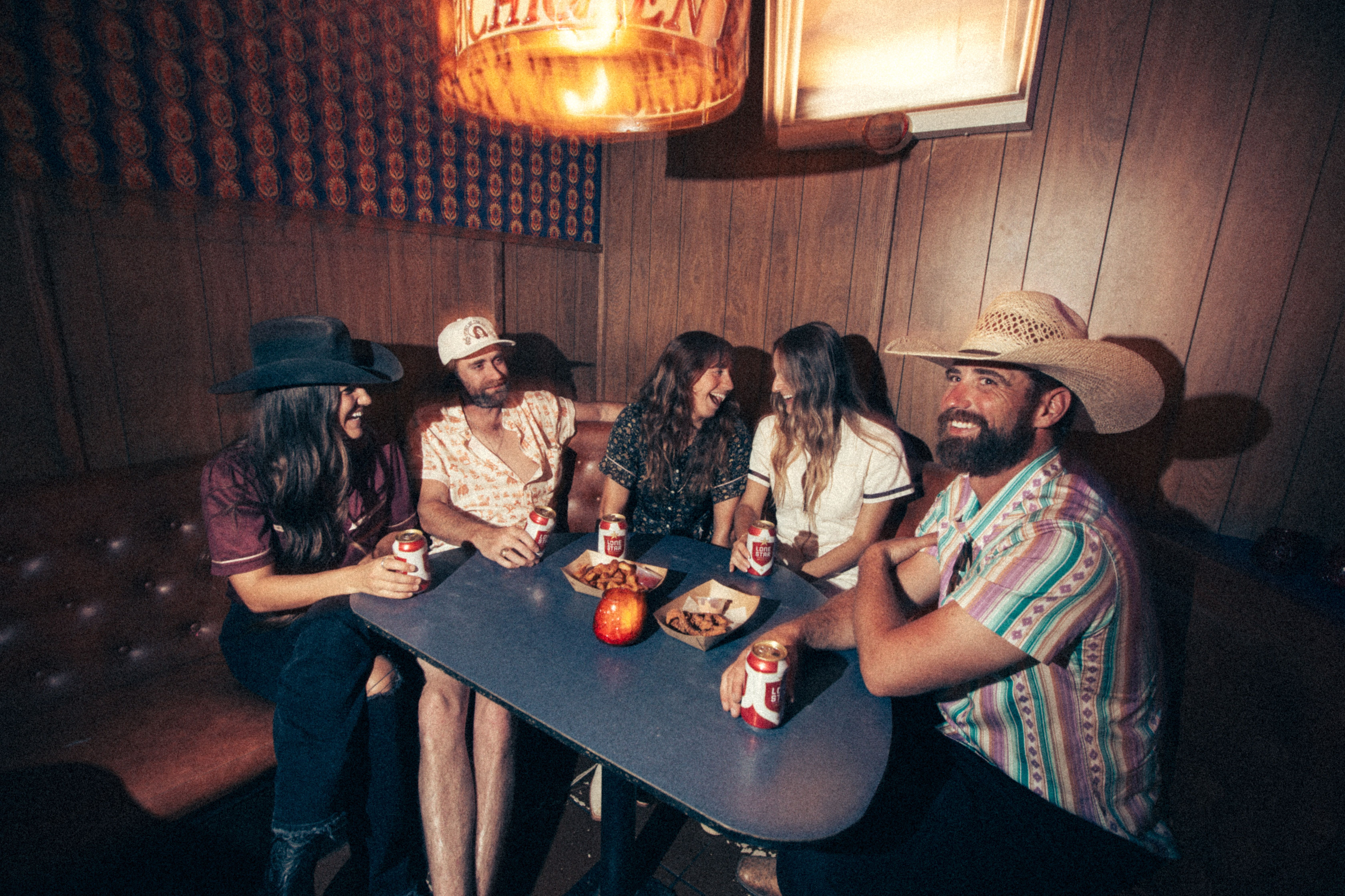 Five people in Sendero apparel sharing a table in a wood-paneled room