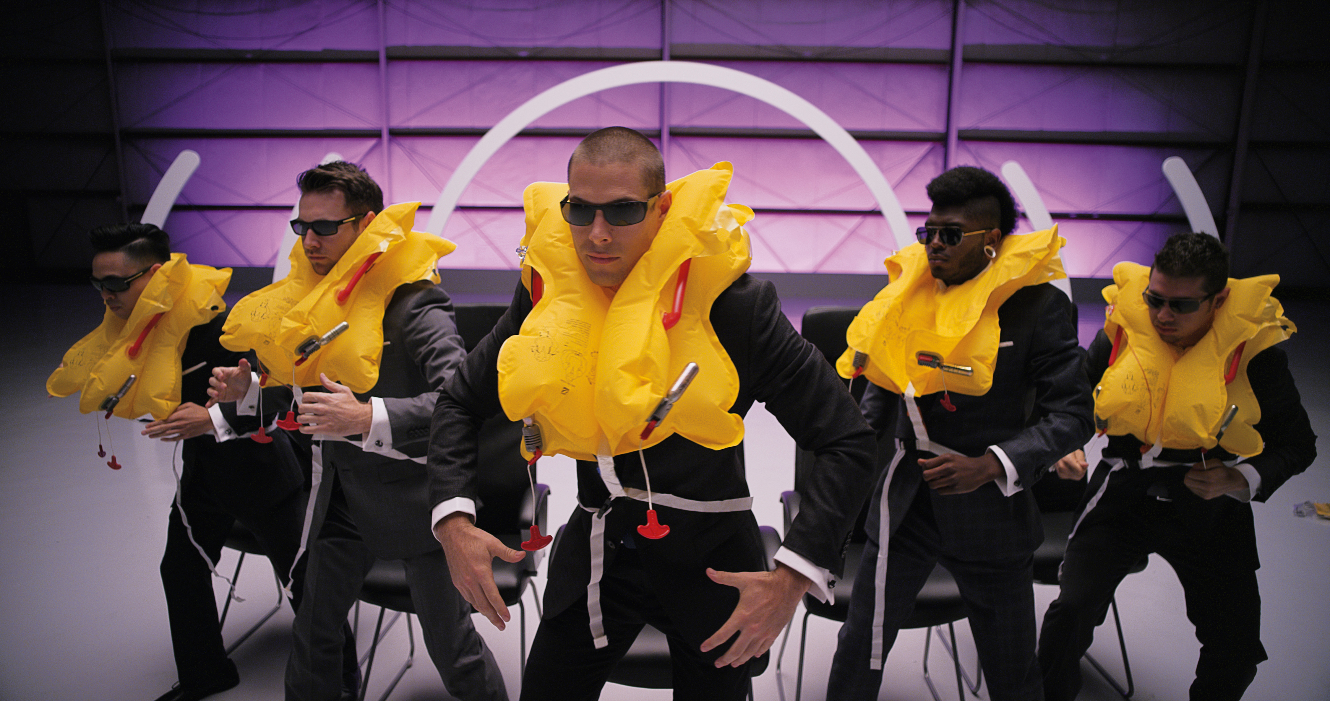 Performers in sunglasses and yellow life jackets in Virgin America's musical safety video