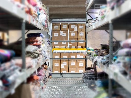Folded clothing stored on shelves in a fulfillment warehouse