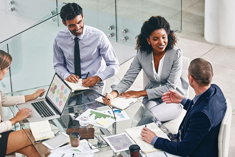 Professionals in a meeting around a glass table, an illustrative image supplied by HyNote