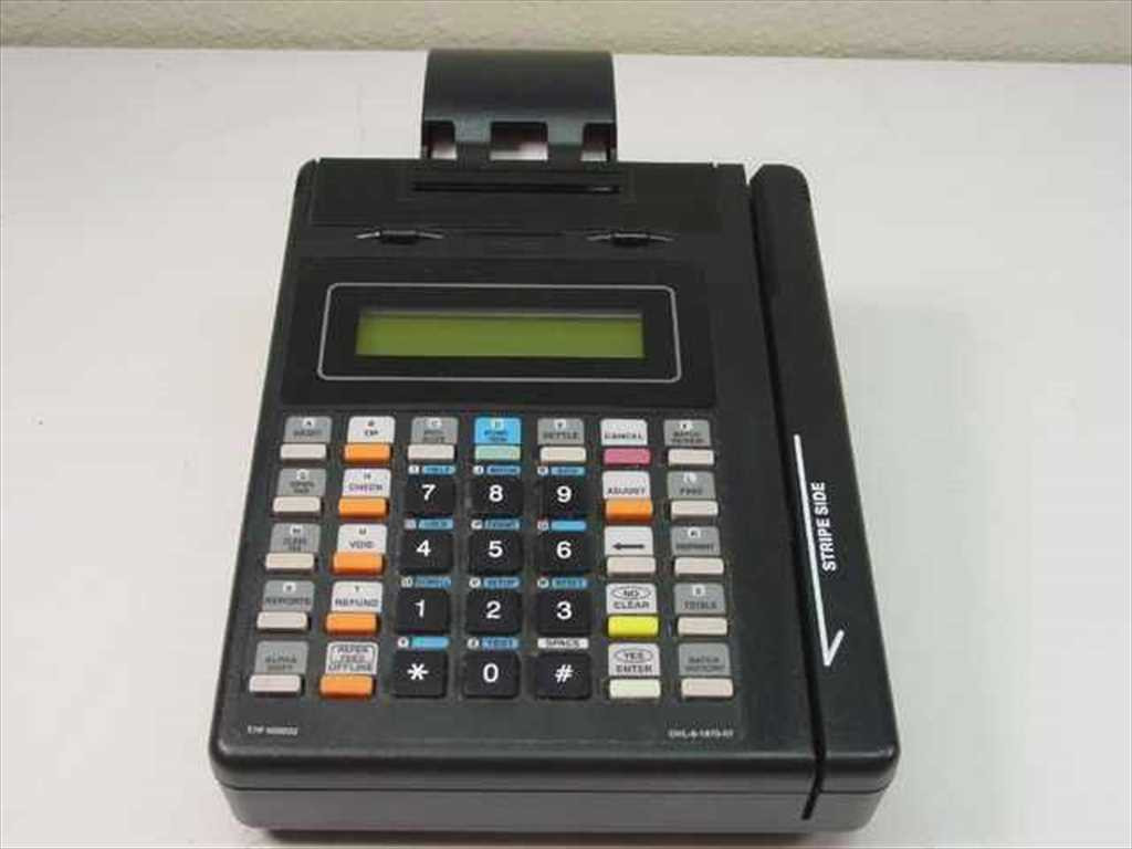 An older Hypercom T7P-T terminal with a narrow green display, many function keys and a right-side magnetic stripe reader