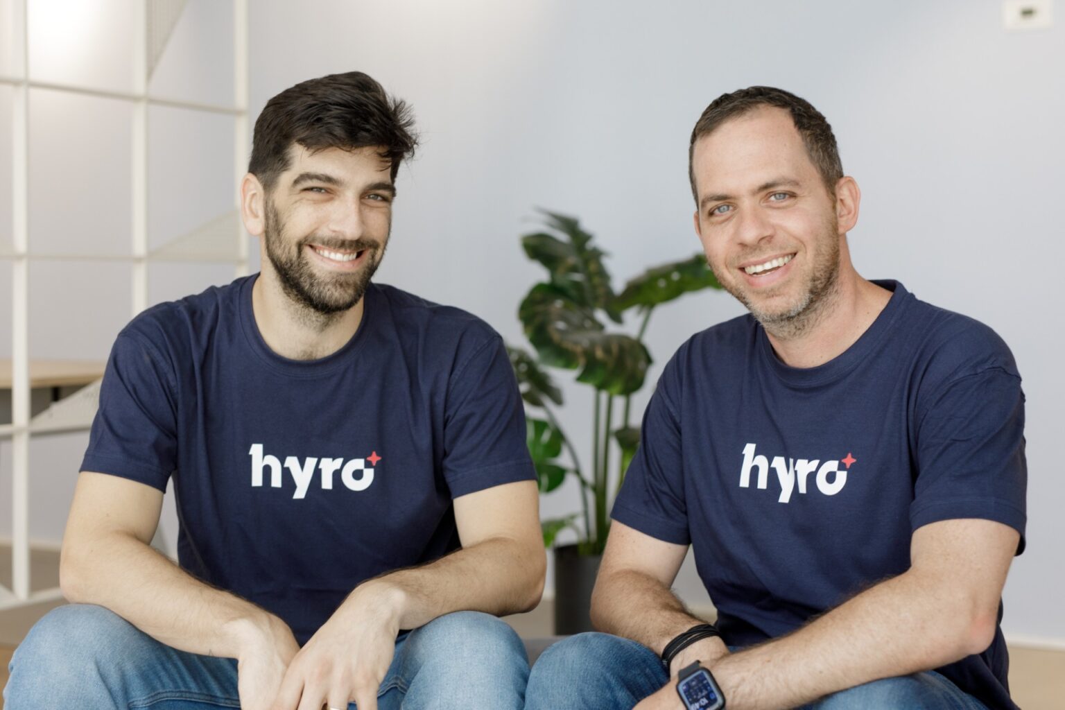 Hyro co-founders Rom Cohen and Israel Krush seated together in Hyro shirts