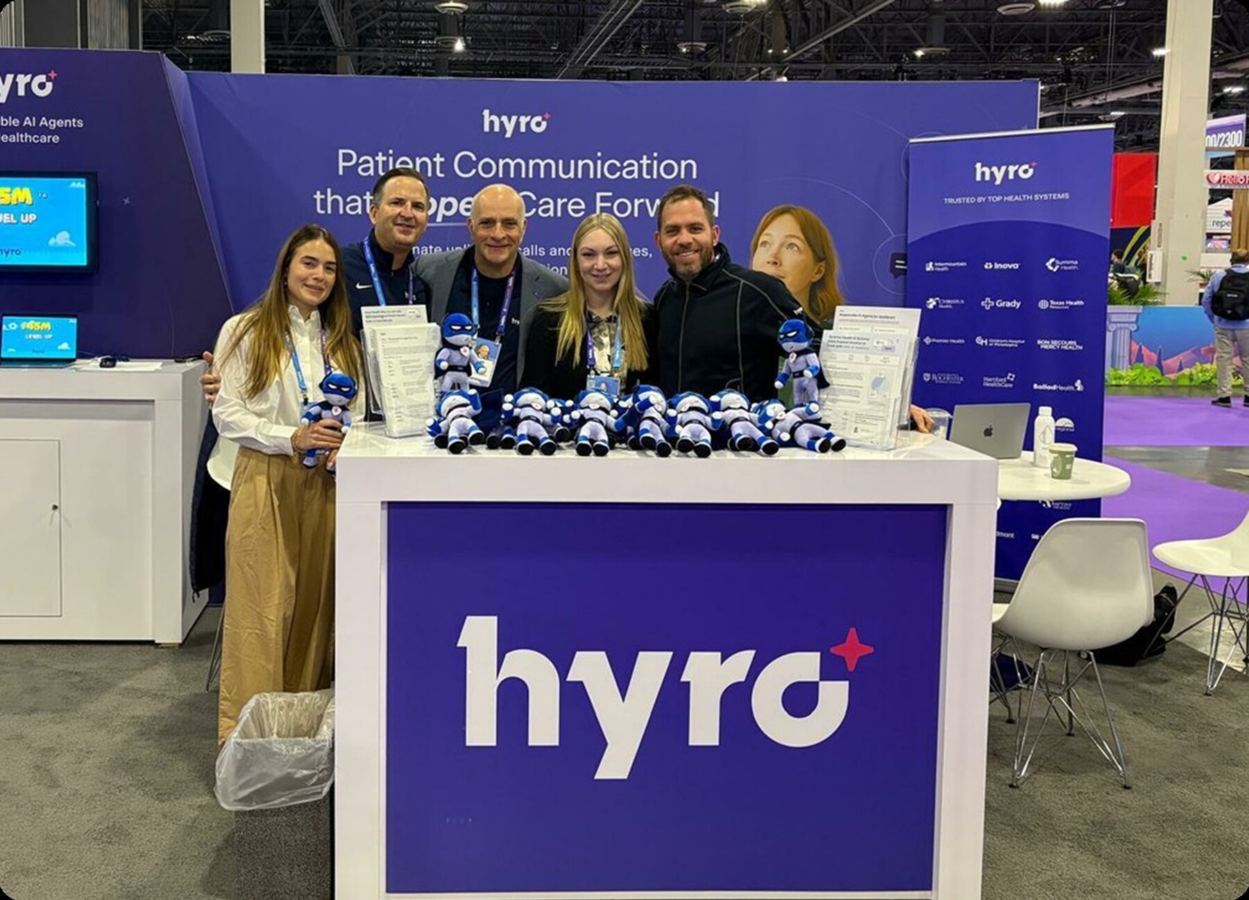 Hyro team members standing at the company's booth at HLTH 2025