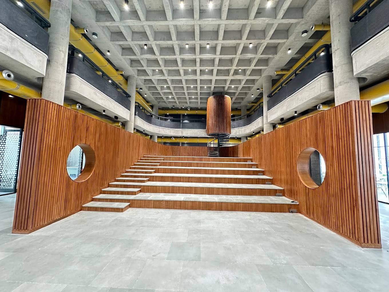 Wide stepped seating and exposed concrete structure inside the i-Hub campus