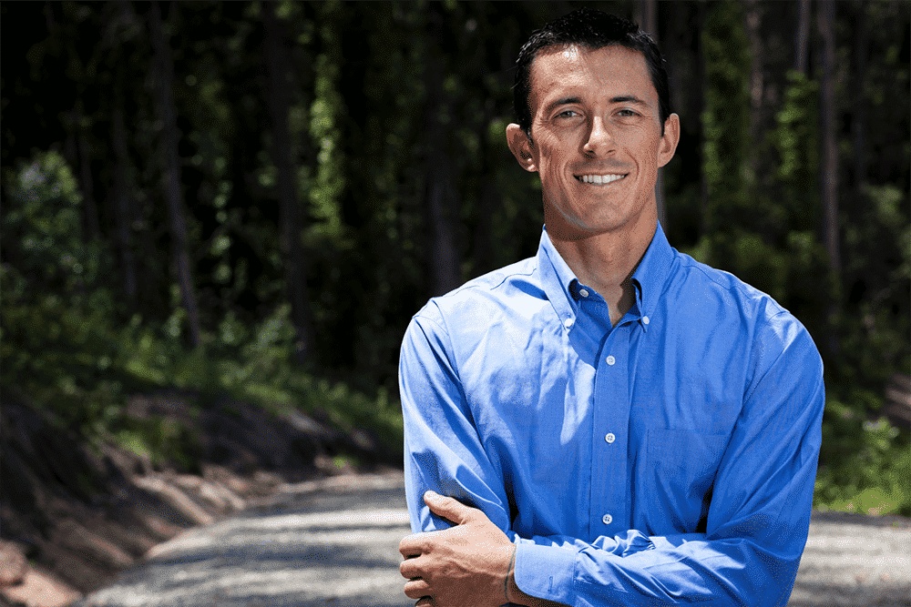 Ian McHenry in a blue shirt, photographed outdoors for his IdeaMensch interview