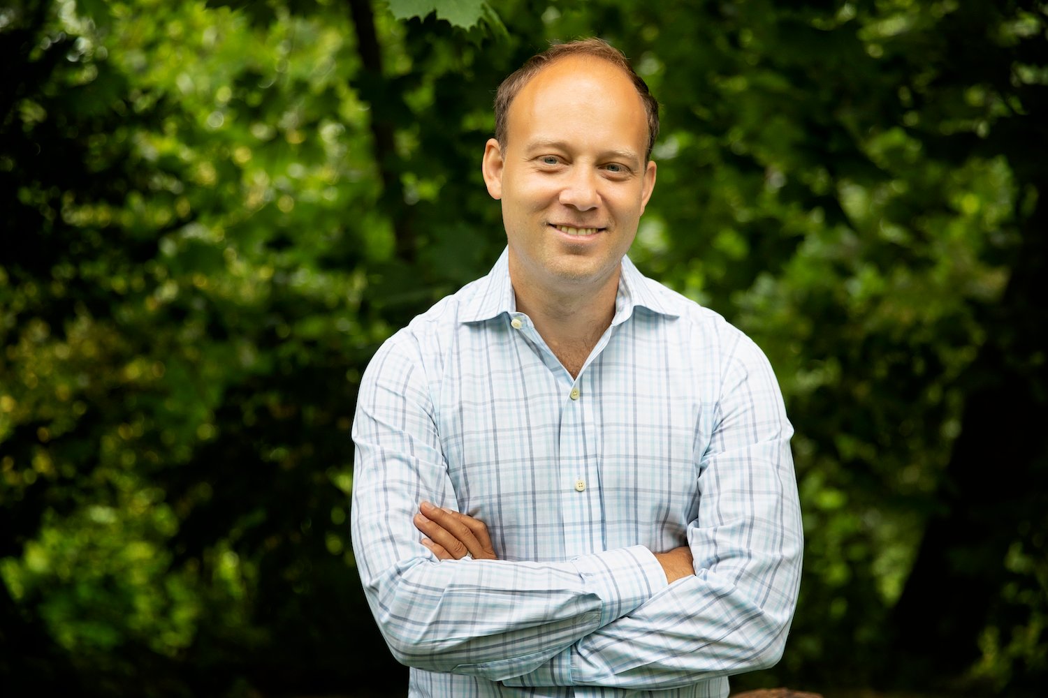 Ian White standing outdoors with his arms folded, in a checked shirt