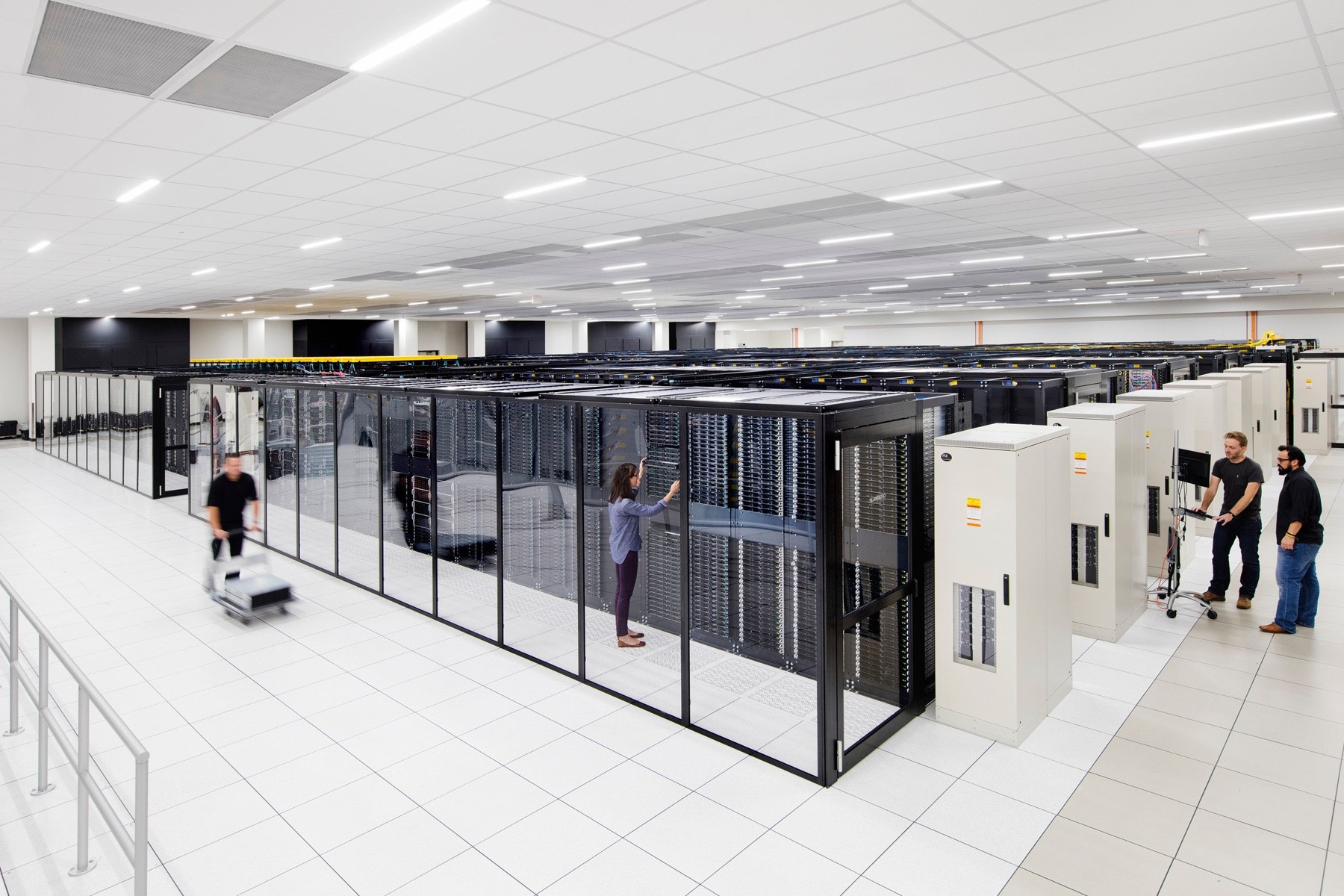 Staff working among server racks in an IBM data center