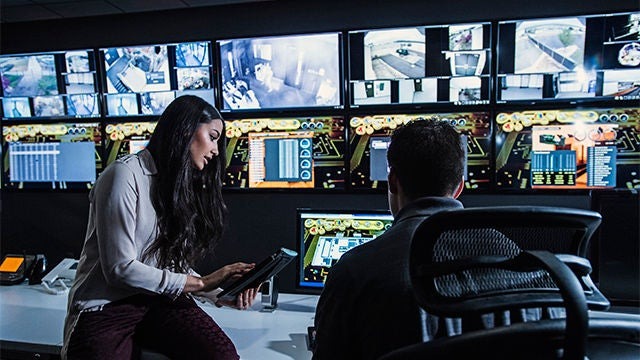 Two people reviewing information in a control room