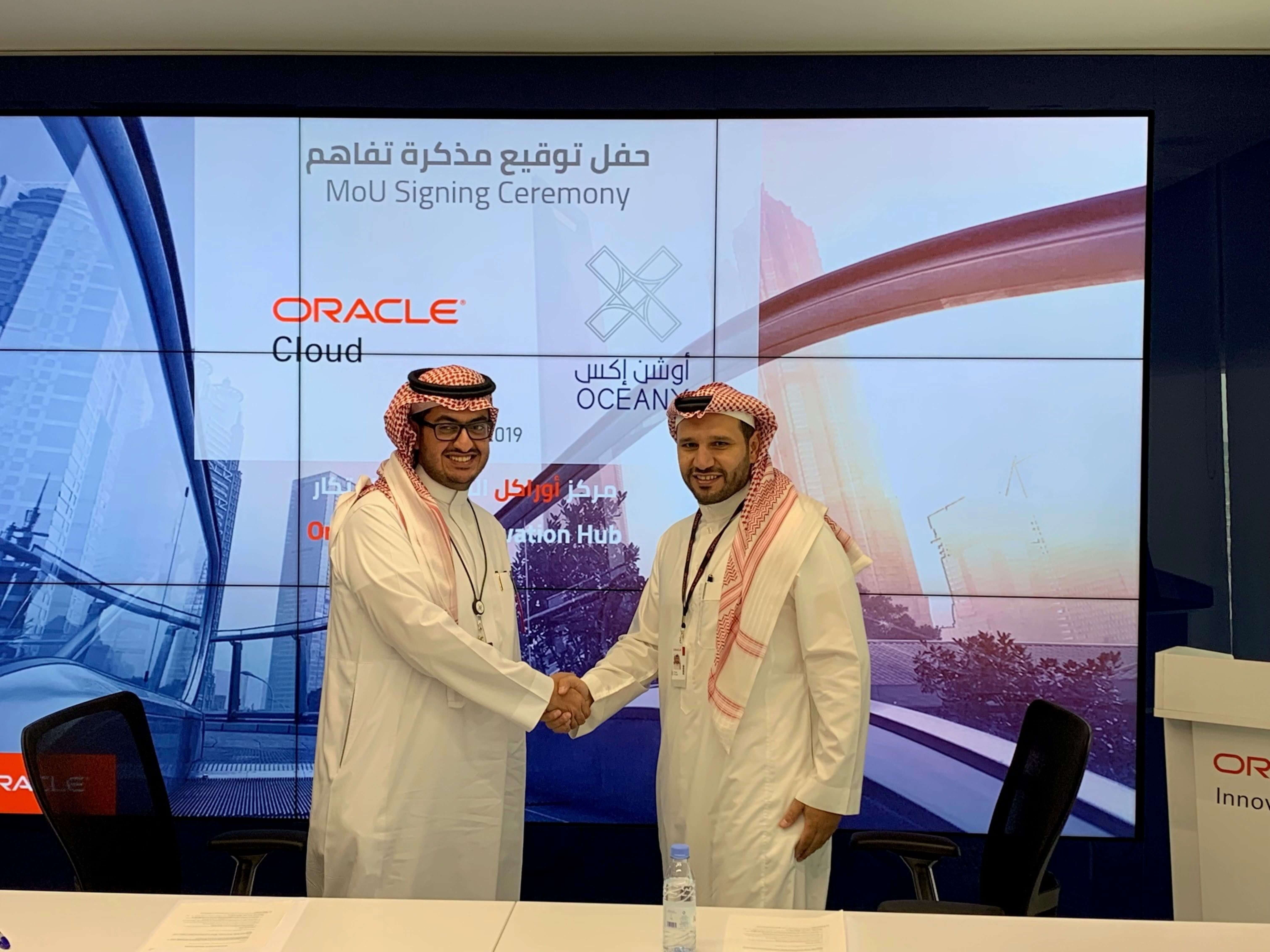 Ibraheem Alzuhimeel, left, shakes hands with Oracle’s Fahad Al Turief at the 2019 memorandum signing