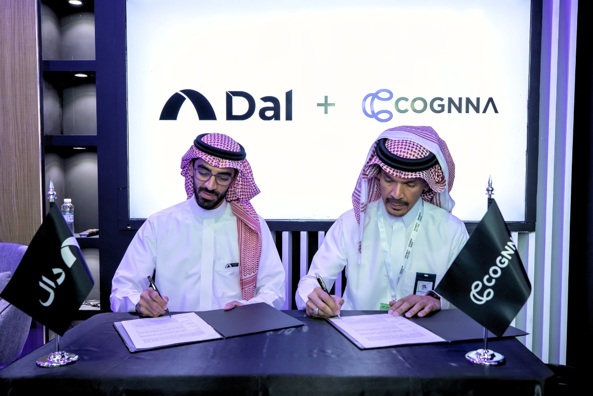 Ibrahim Alshamrani, left, and a Dal representative sign partnership documents at Money20/20