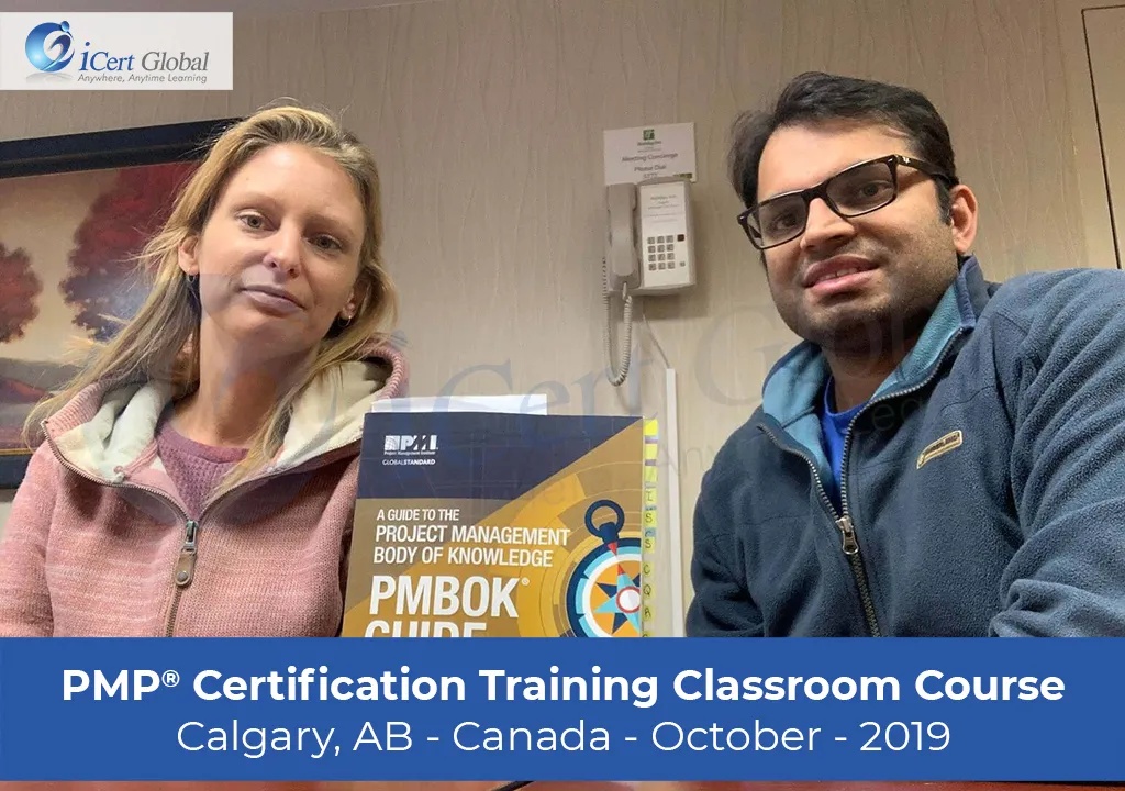 Two participants with a PMBOK Guide in a company gallery photograph labelled Calgary, October 2019