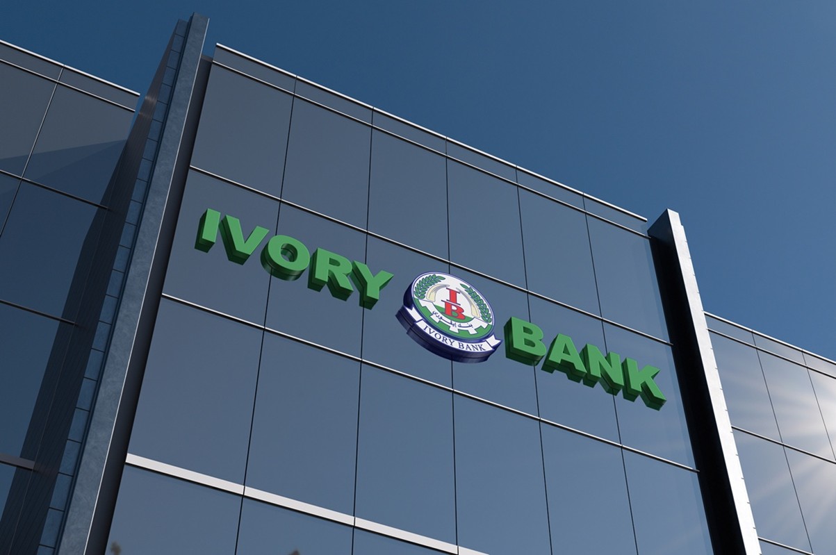 Ivory Bank’s green lettering on a glass-fronted building beneath a blue sky